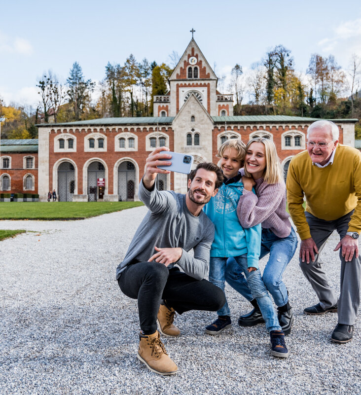 Family taking a selfie in front of the Hauptbrunn building