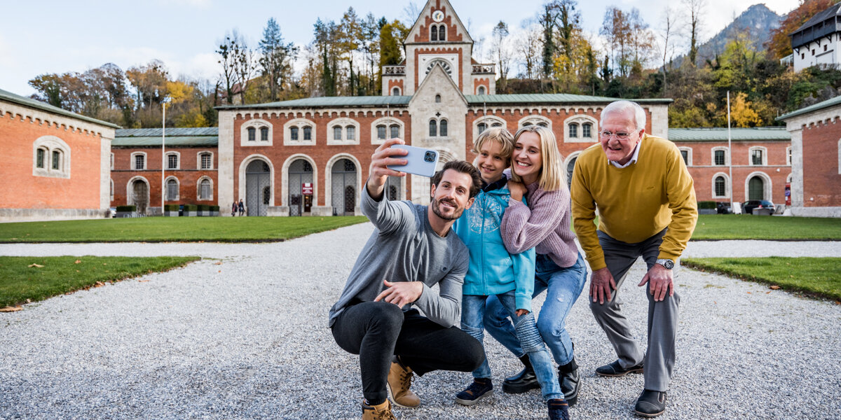 Family taking a selfie in front of the Hauptbrunn building
