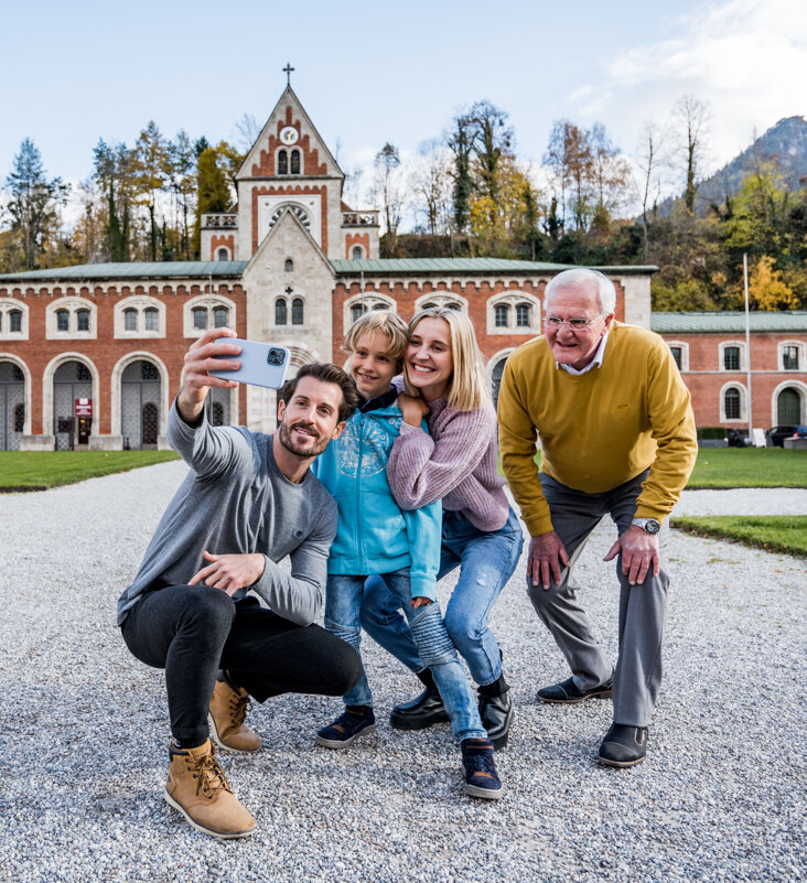 A family takes a selfie in front of the main entrance to the Alte Saline in Bad Reichenhall